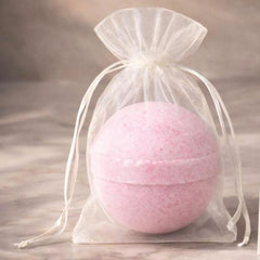 Pink Velarte bath bomb with a smooth spherical shape, designed for relaxing baths and colorful water effects.