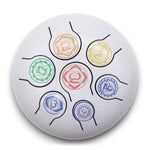 Steel tongue drum with 7 chakra symbols, 18cm diameter, by AW Gifts, designed as a spiritual music accessory.