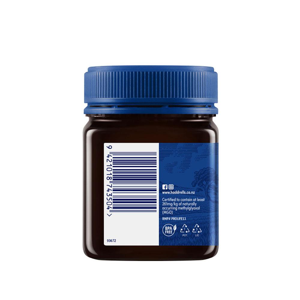 Herbalistas Haddrells Manuka Honey UMF10+ MGO83+ in 250g jar, showcasing golden, viscous honey with a textured lid and label.