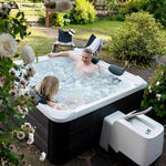 VIKING FITNESS MSpa Oslo outdoor hot tub in a garden setting with seating and surrounding greenery.