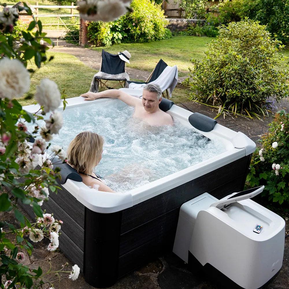 VIKING FITNESS MSpa Oslo outdoor hot tub in a garden setting with seating and surrounding greenery.