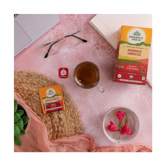 Organic India BIO Moringa & Hibiscus tea infusion bags; colorful dried herbs and flowers in a box.